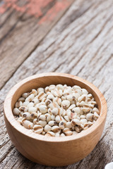 Job's tears in bowl on rustic wooden table