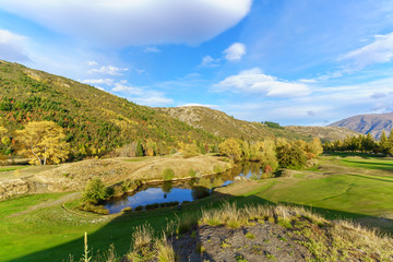 Female golfer is playing on Arrowtown Golf course in Autumn , South Island of New Zealand