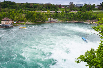 Rhine Falls landscape. Touristic boats in fast river
