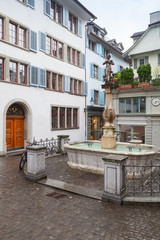 Fototapeta na wymiar Small square with fountain in old town of Zurich