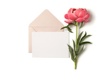 Paper mockup A5 with envelope and pink peony flower. Blank letter on white background, top down...