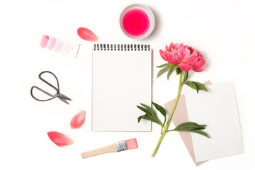 Empty open notebook mockup with pink peony flower and painting supplies. Blank paper letter on...