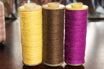 purple,brown,yellow colorful bobbin on wood background