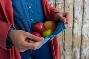 Mid section of woman carrying fruits carrying in shirt