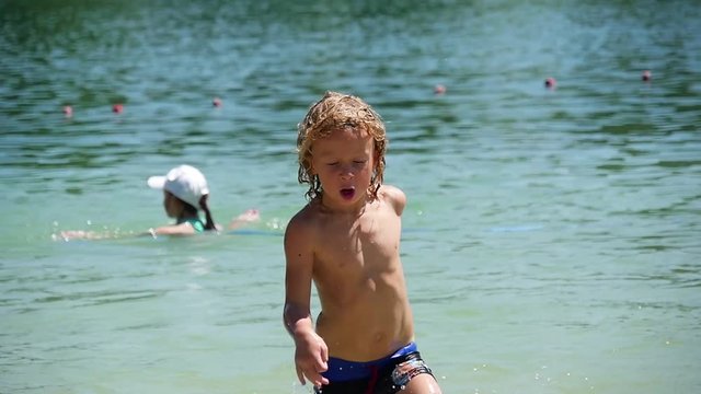 little blond boy playing at the beach