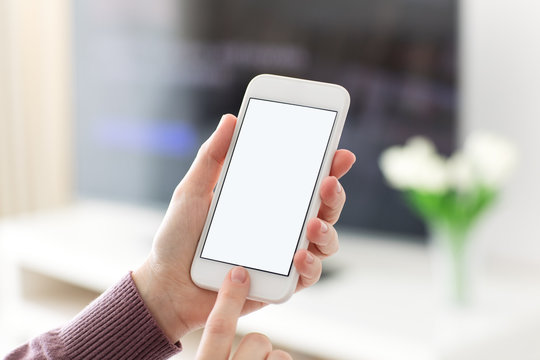 Female hands holding phone with isolated screen in room