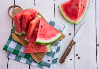 Watermelon cut in slices on white wooden table