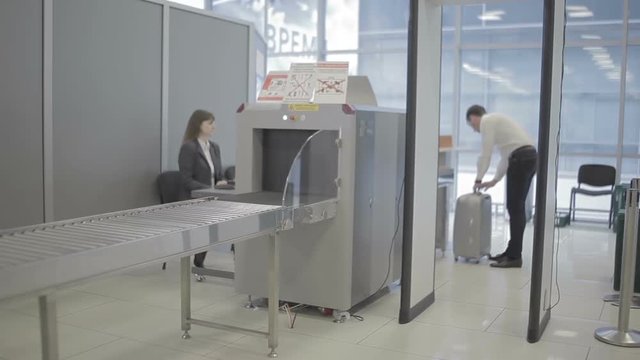 Man checks his baggage with x-ray machine in the airport