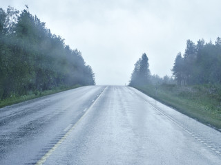 Heavy summer rain makes highway very wet and slippery. Road safety background.
