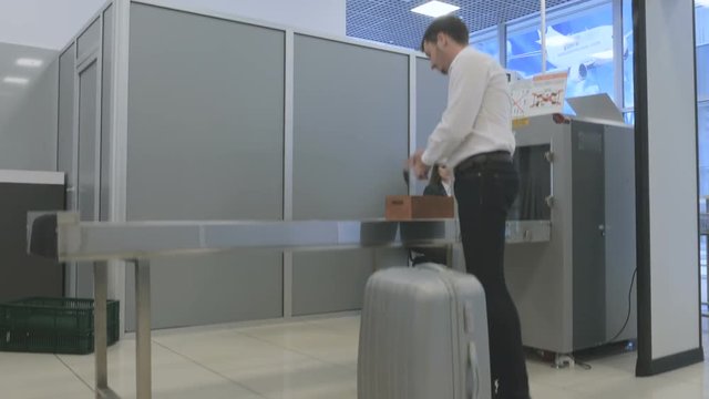 Businessman take suitcase from belt in the check room and go on a bord of plane