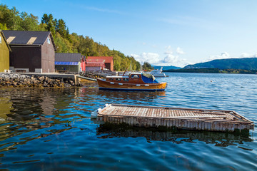Fototapeta na wymiar Red fishing rorbu huts by the fjord in near Alesund in Norway