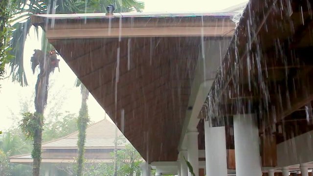 The water drips from the roof during the rain.