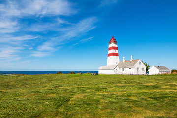 Fototapeta na wymiar Alnes lighthouse at clear sky at Godoy island near Alesund, Norway