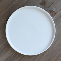 Modern white plate on wooden background 