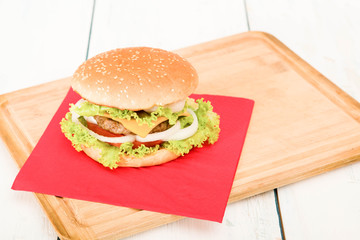 hamburger with vegetables, on wooden table