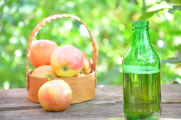 Two Glasses of cider with apples and bottle on rustic wooden background