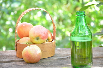 Two Glasses of cider with apples and bottle on rustic wooden background
