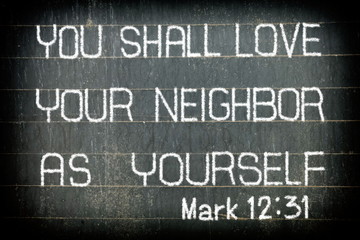"YOU SHALL LOVE YOUR NEIGHBOR AS YOURSELF" Bible Verse Chalk Writing on Old Chalkboard Background.
