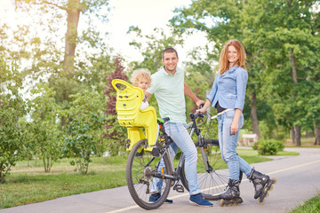 Fototapeta premium Full length shot of a happy young family enjoying cycling and rollerblading together at the local park copyspace active people lifestyle leisure children parenthood love concept.