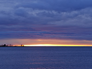 Fototapeta na wymiar Beautiful dark purple clouds over murky sea at sunset. Natural background.