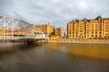Naklejka premium View on the old warehouses and iron bridge in Hafen district of Hamburg city during the sunset in Germany