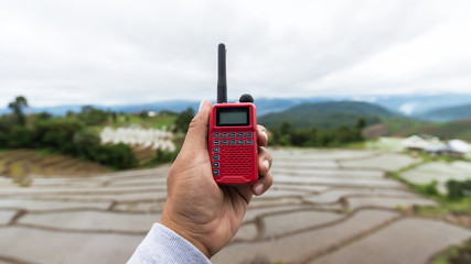 Radio communication(walkie-talkie radio) in hand, on Natural background,Portable radio transceiver in hand, nature on background