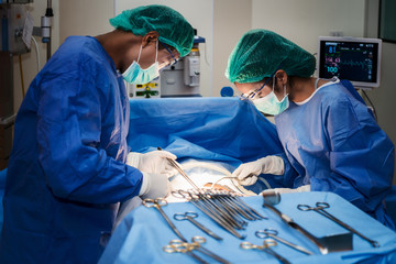Asian doctor and an assistant in the operating room for surgical venous vascular surgery clinic in...