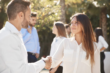 Businesswoman shaking hands with partner outside