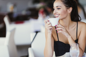 Beautiful woman drinking coffee in restaurant