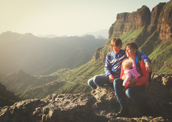 happy couple with small baby travel in mountains