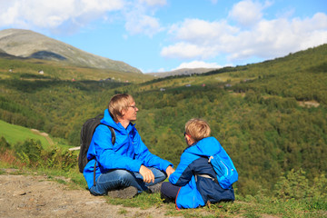 Naklejka na ściany i meble father and son travel hiking in Norway looking at nature