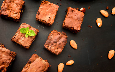 homemade chocolate brownies on dark background, top view