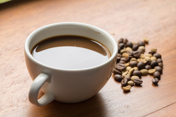 Coffee in the cup on woodden bar.