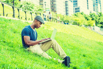Young African American Man working on laptop computer outdoor in New York