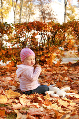 happy little child, baby girl laughing and playing in the autumn on the nature walk outdoors