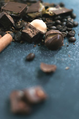 Coffee beans and tiles of dark chocolate on a dark matte background.