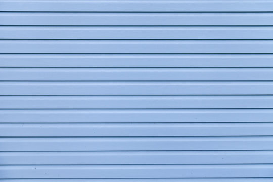 Blue vinyl wooden siding panel background with imitation wood texture.