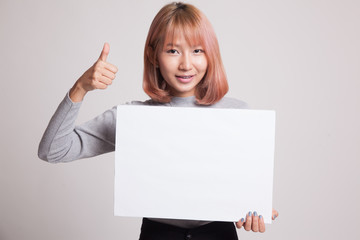 Naklejka premium Young Asian woman show thumbs up with white blank sign.