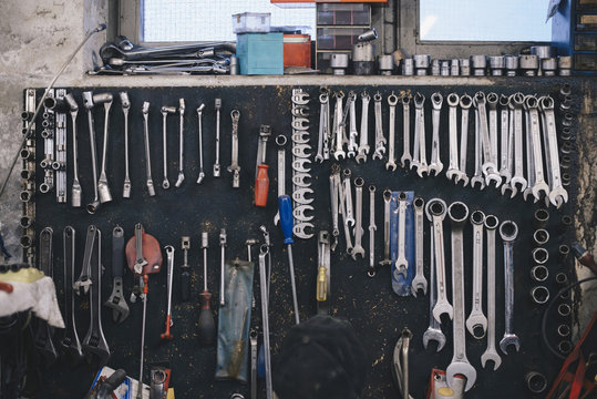 Various work tools hanging on wall at auto repair shop