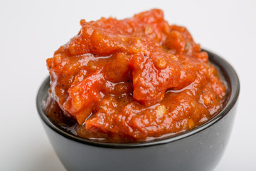 Close up of tomato sauce in a black cup