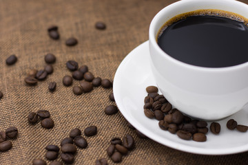 Coffee espresso and coffee cup and beans on table,Tea cup on table,warm cup of coffee on brown background,