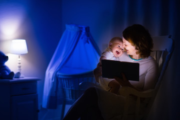 Mother reading a book to little baby