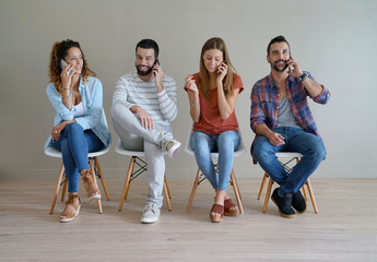Fototapeta premium Young people in waiting room talking on phone