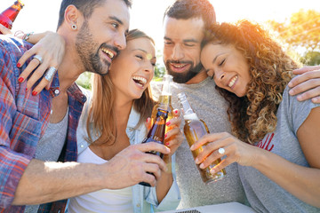 Group of friends gathering in bar drinking beers