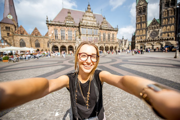 Portrait of a young woman tourist standing on the central square of Bremen city, Germany