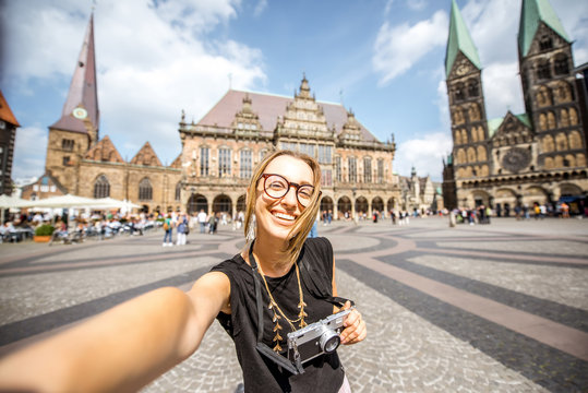 Portrait of a young woman tourist standing on the central square of Bremen city, Germany