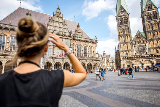Young woman tourist enjoying great view on the city hall building and church in the centre of Bremen, Hamburg