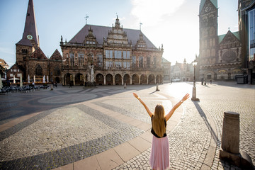 Young woman tourist enjoying great view on the city hall building and church in the centre of Bremen, Hamburg