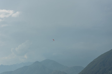 Fototapeta na wymiar paragliding above lake water in front of mountain