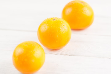 Line with yellow ripe fresh tomatoes on old white rustic wooden planks